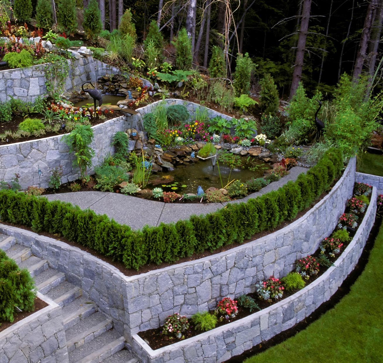wal-img1 Nestled in the serene outskirts of Salem, Oregon, this terraced garden boasts stone walls, vibrant greenery, colorful flowers, and a tranquil pond with a cascading waterfall. It's a perfect off-the-road escape.